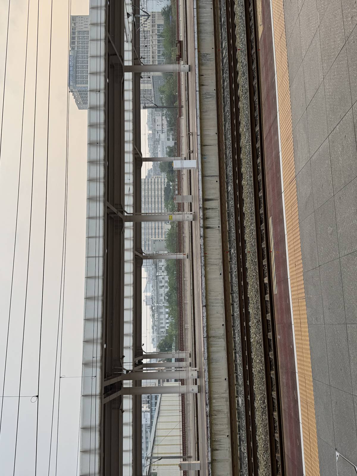 站台边缘特写，黄色盲道与安全线、铁轨、站台屏蔽结构